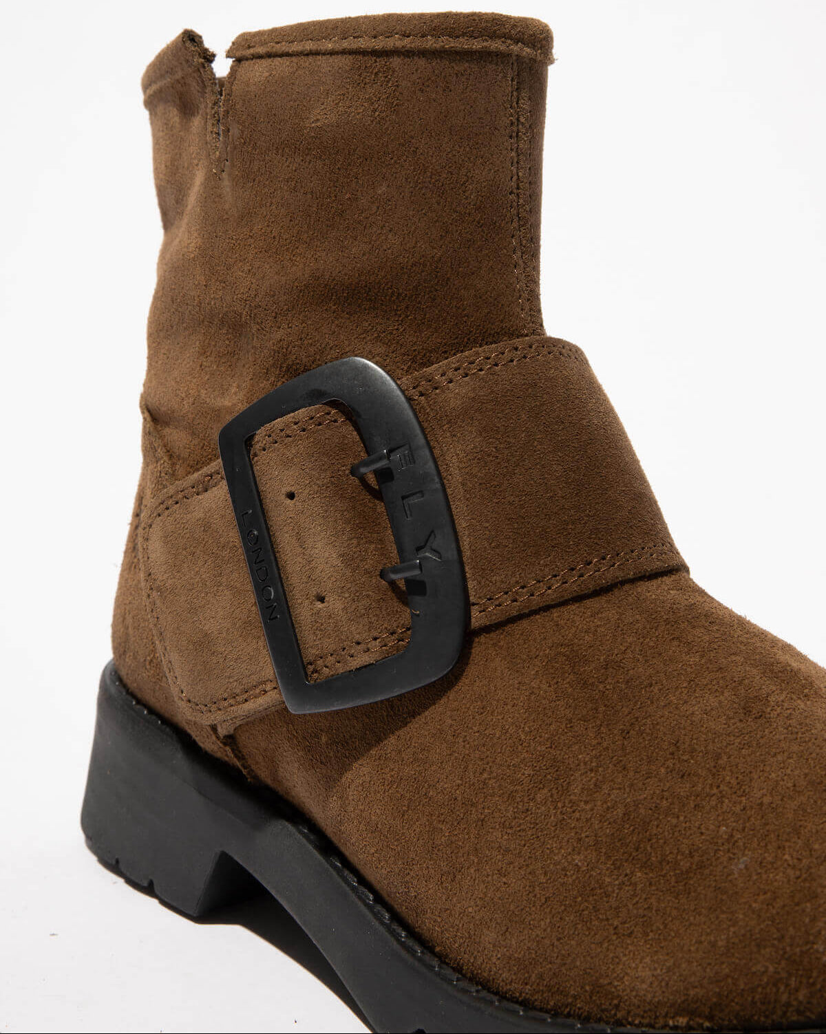 Brown suede boot with a black buckle on a white background