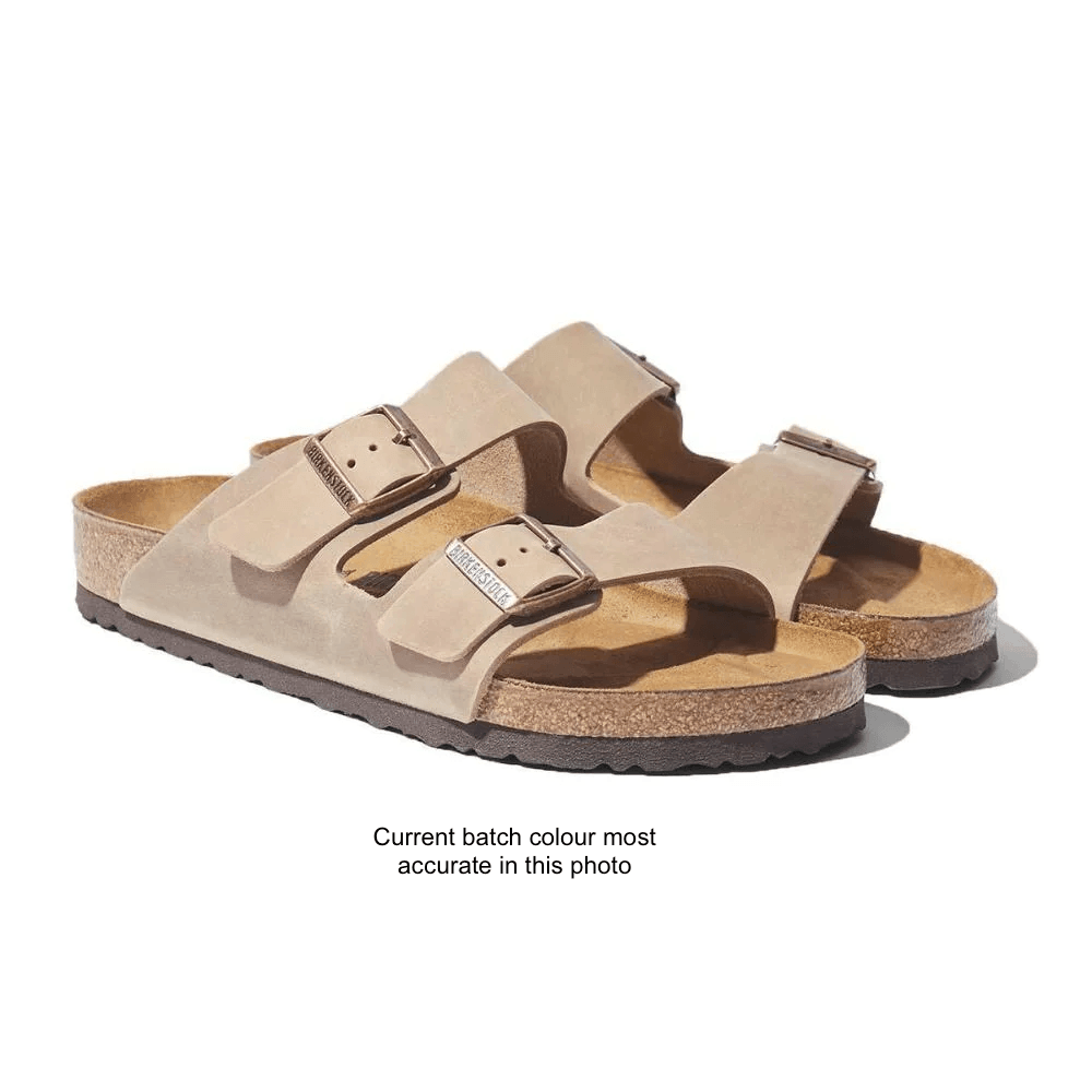 A single Birkenstock Arizona double-strap slide sandal in tan suede, featuring a cork footbed, adjustable buckles, and a black outsole, shown on a white background.